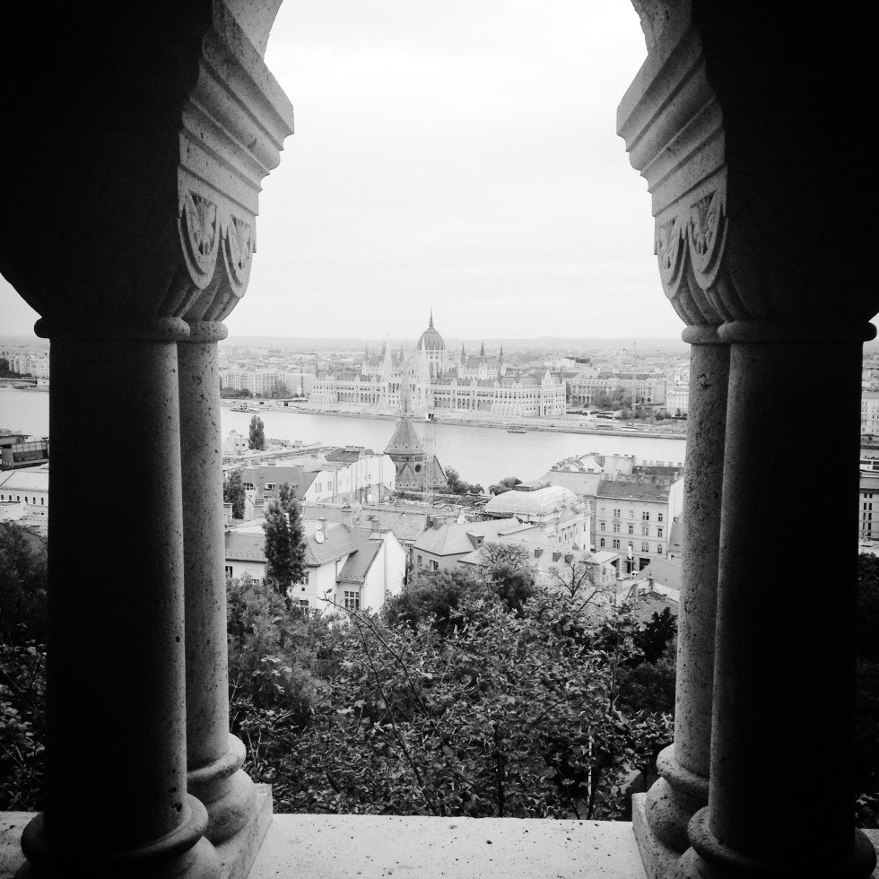Photograph. 'Fisherman's Bastion, Budapest, Hungary.' View of the Hungarian Parliament Building from the Fisherman's Bastion, on the Buda side of the Danube. Buda is the ancient capital of Hungary, and one of three territories that make up the modern city of Budapest. In 1686 Buda was reconquered from the Ottoman Empire.@davidasutton @sketchbookexplorer Facebook.com/davidanthonysutton #b&w #photography #budapest #hungary #travel #travelblog #buda #fishermansbastion