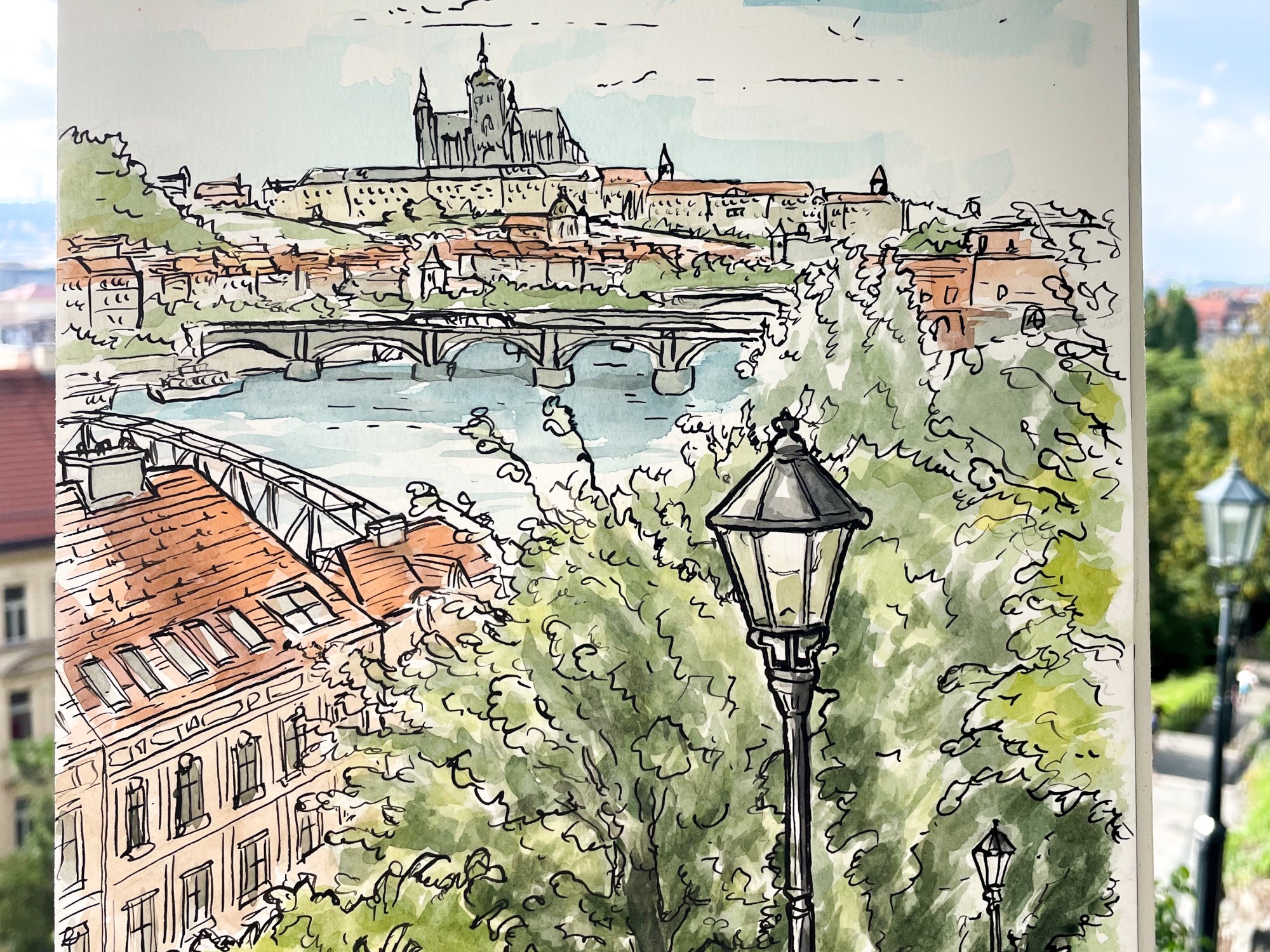 Urban Watercolor painting – V Pevnosti 159/5b, Vyšehrad, Prague, Czech Republic. ‘Photo of watercolor painting of the view of Prague Castle from Vysehrad castle.' Vysehrad was in competition with Prague castle in the 11th century for the honor of being the royal seat of power. sketchbookexplorer.com #sketch #drawing #art #watercolor #watercolorpainting #praguecastle #vysehradcastle #vysehrad #Prague #praha #czechrepublic #travel #travelblog #travelart