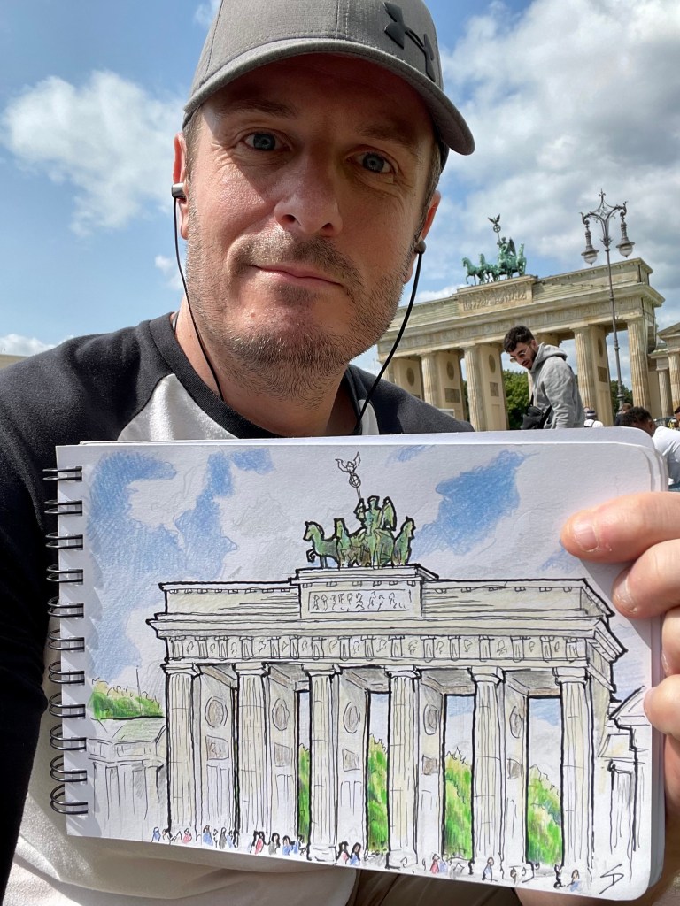 Photo of David Sutton with sketch of the Brandenburg Gate, Berlin